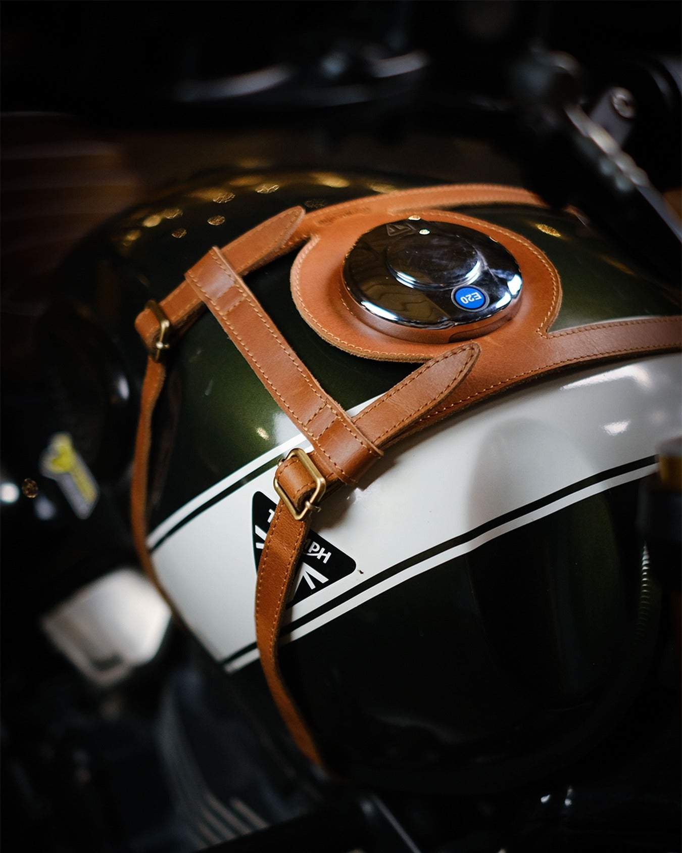 Close-up of a motorcycle helmet with a brown strap on a blurred background