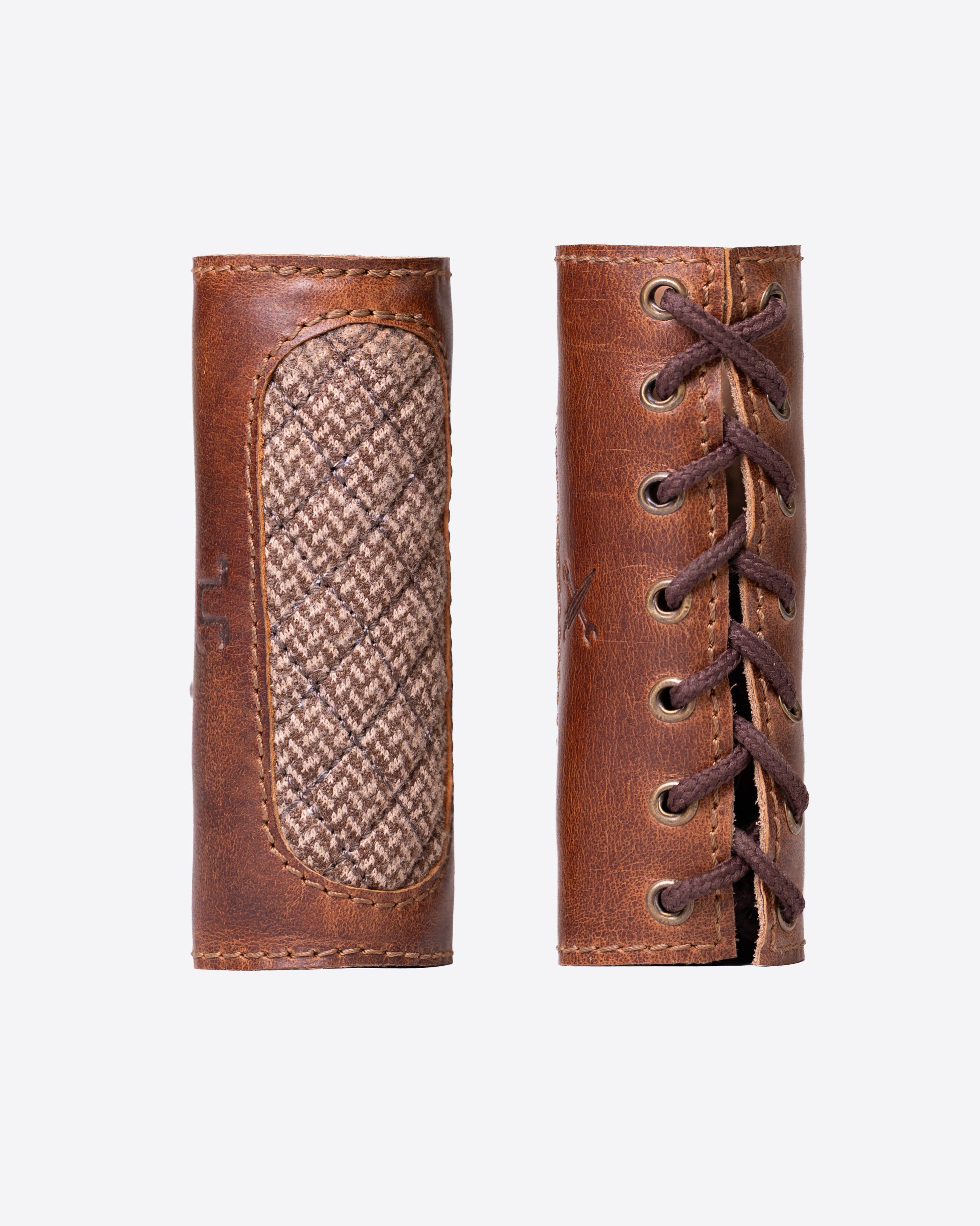 Two brown leather boot lace holders with woven pattern on a white background