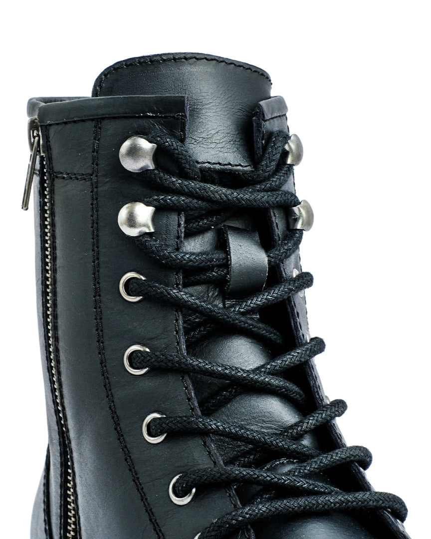 Close-up of a black leather boot with laces on a white background