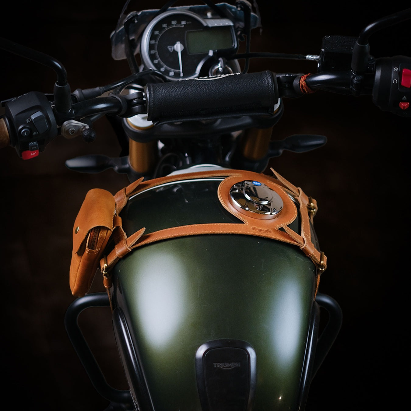 Close-up of a motorcycle's handlebar and dashboard with a dark background