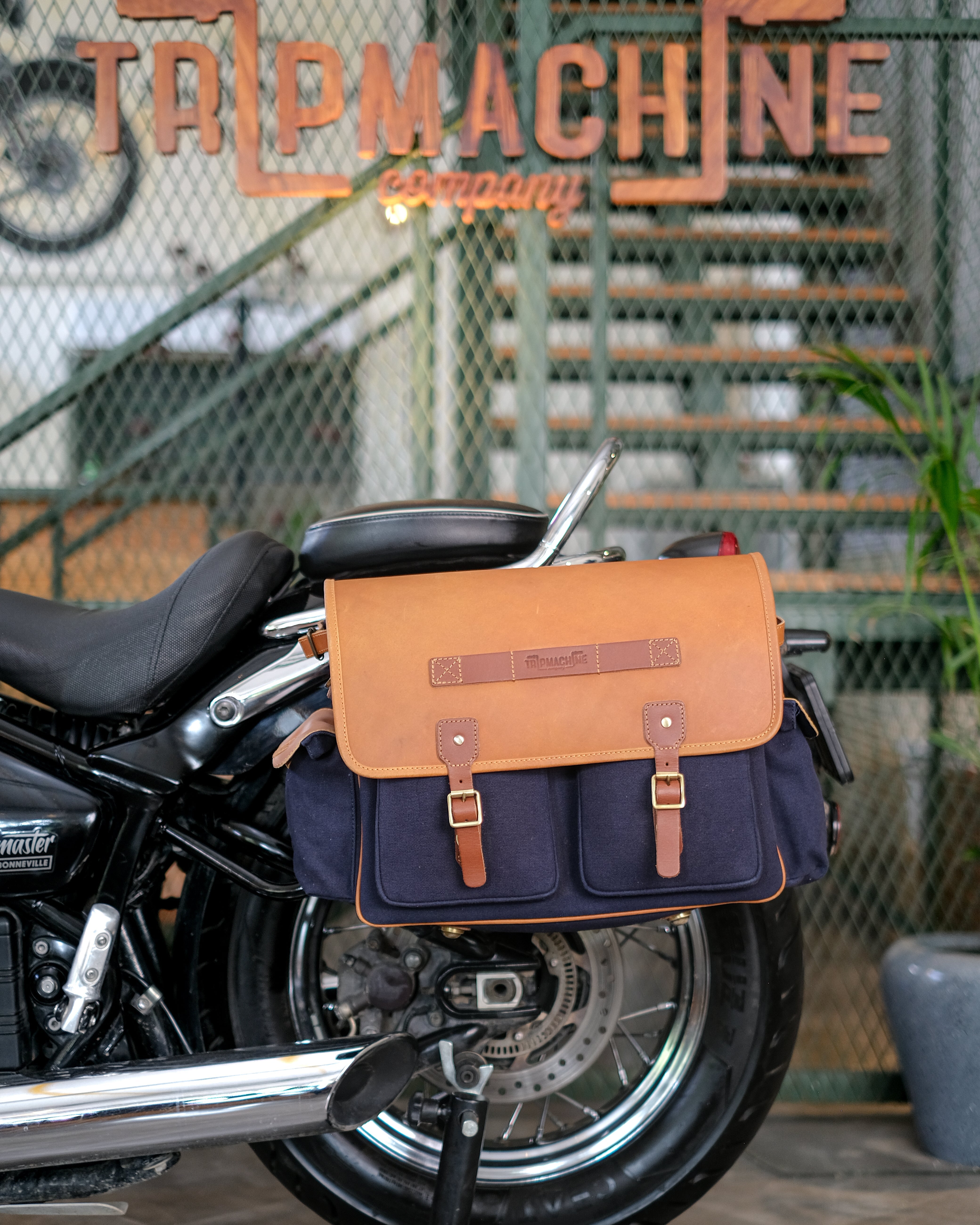 Motorcycle with a saddlebag attached, featuring 'Tail Machine Company' branding.