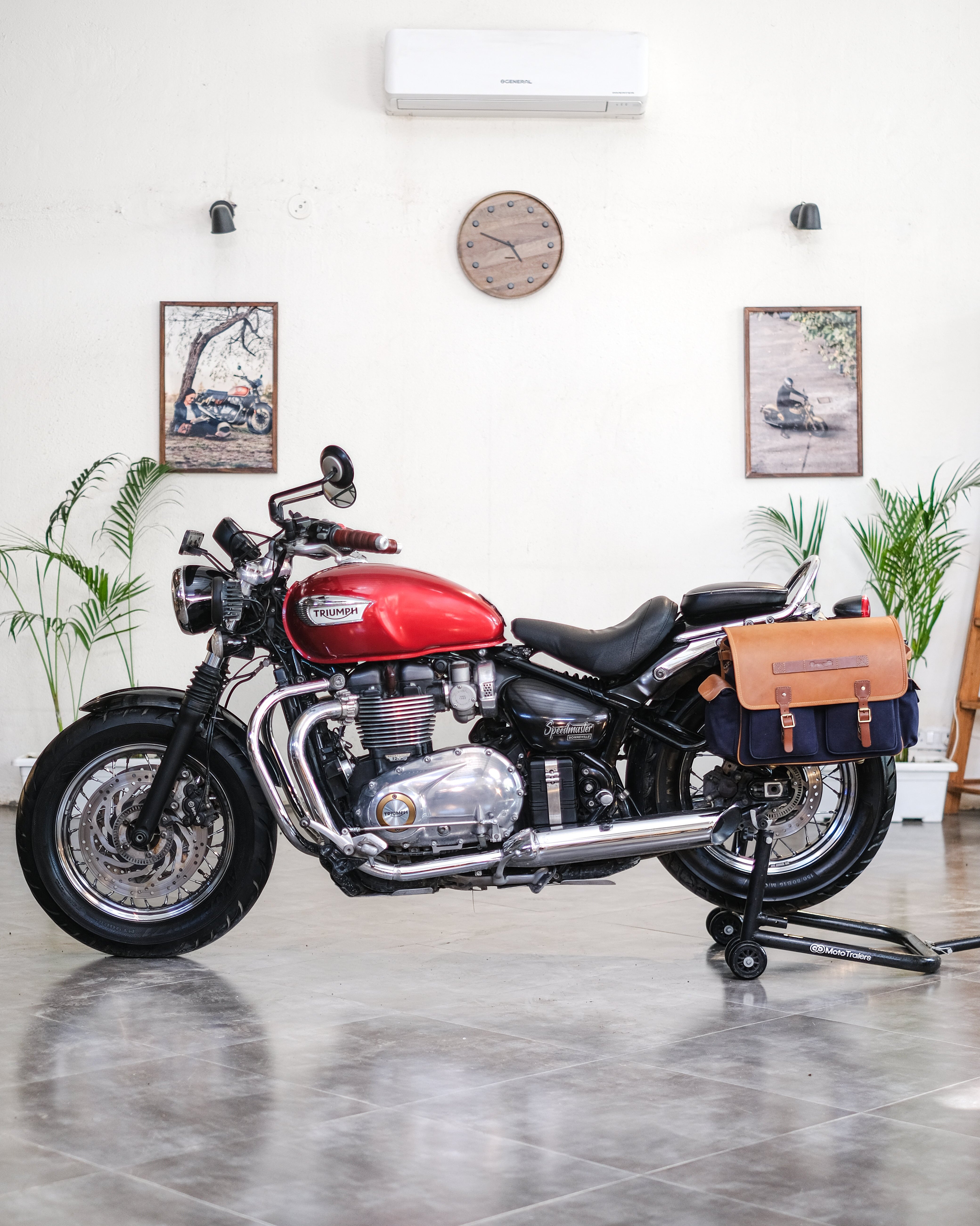 Red motorcycle with leather bags in a showroom setting