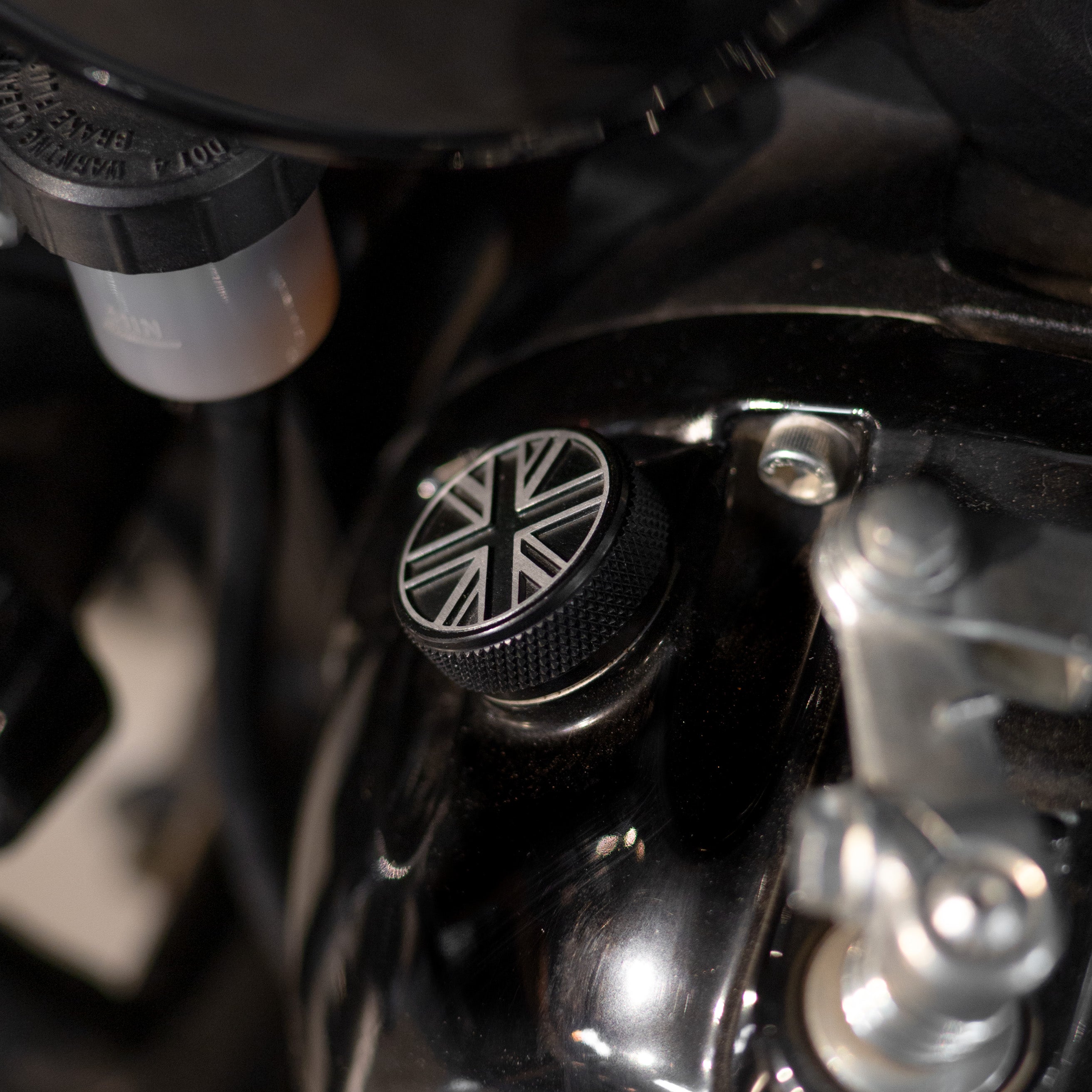 Close-up of a motorcycle handlebar with a Union Jack design on the throttle grip.