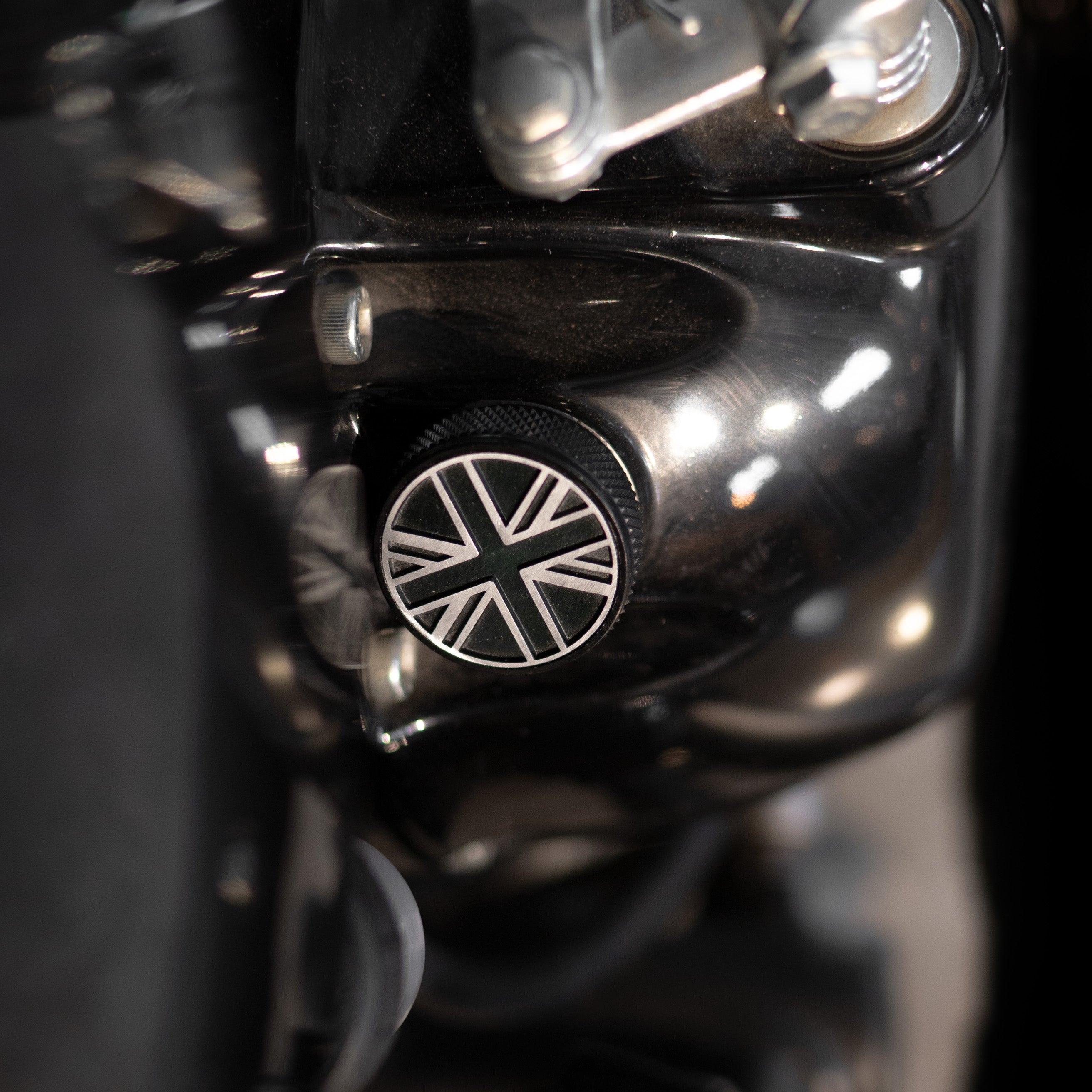 Close-up of a motorcycle handlebar with a Union Jack emblem on a black background