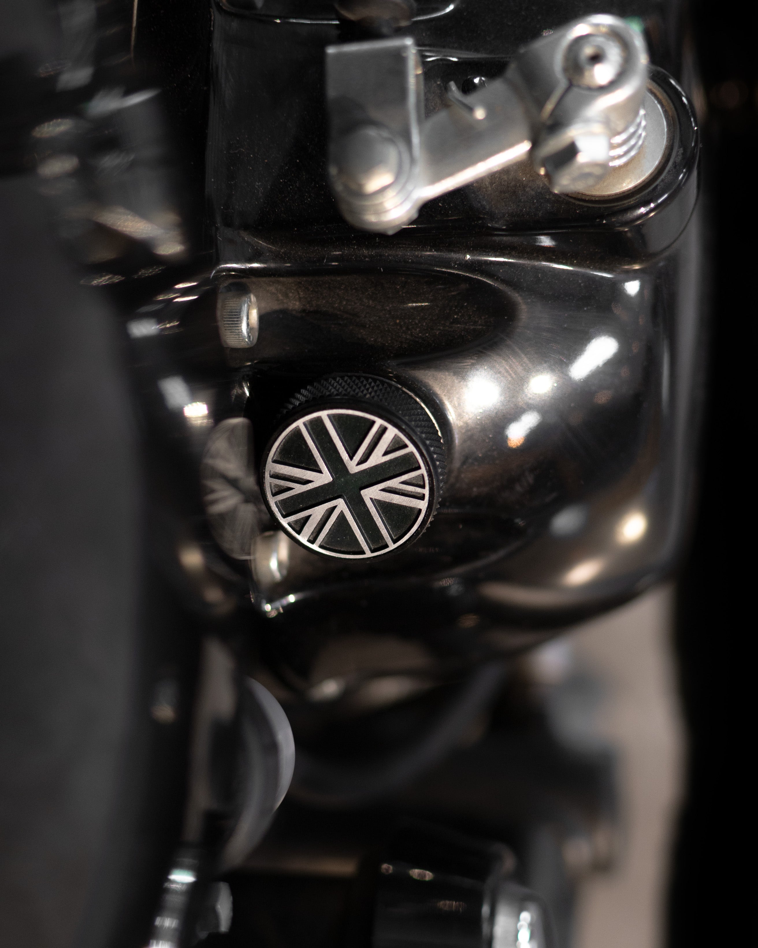 Close-up of a motorcycle handlebar with a Union Jack emblem on a black background