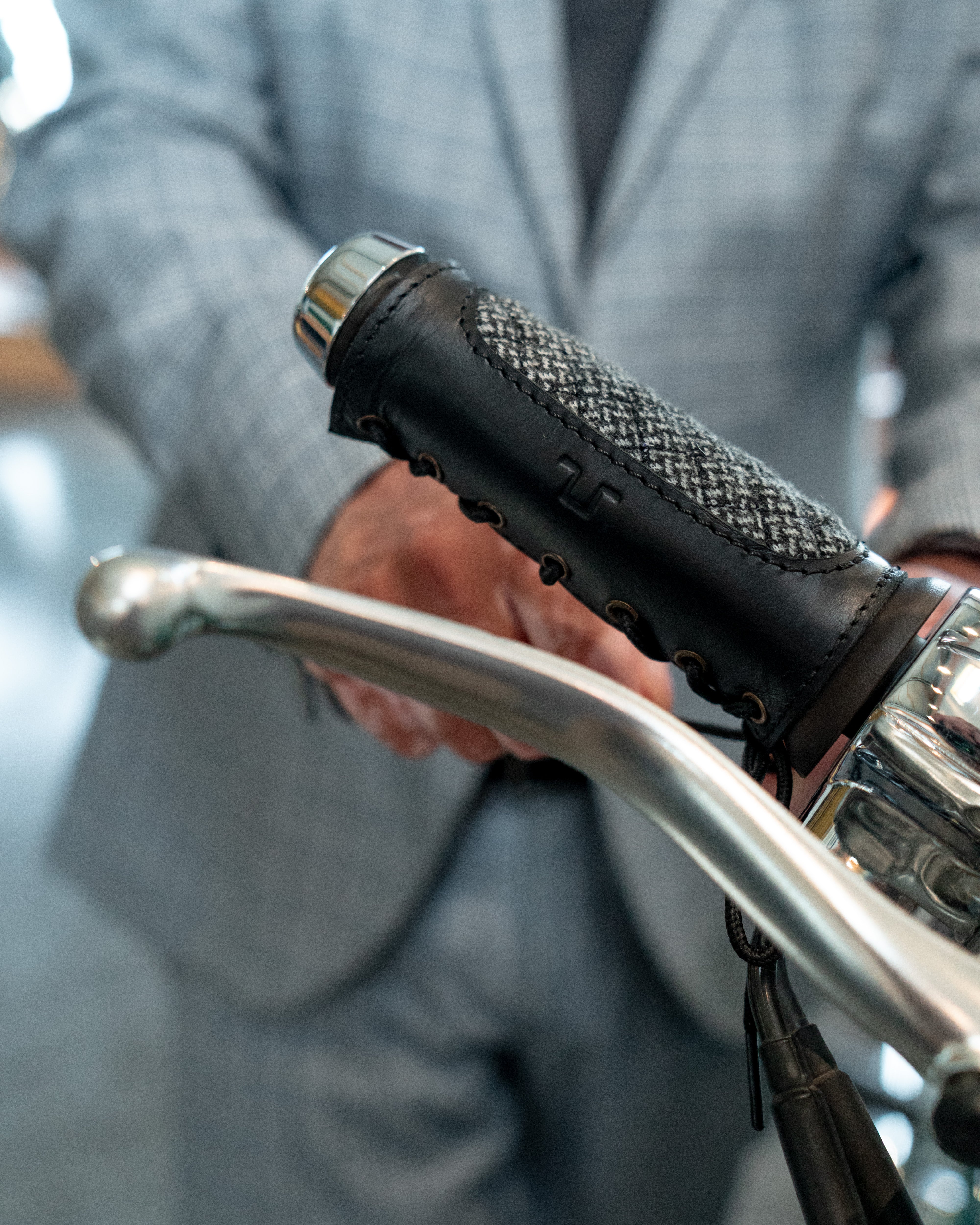 Close-up of a person holding motorcycle handlebars with a blurred background