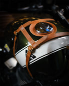 Close-up of a motorcycle helmet with a brown strap on a blurred background