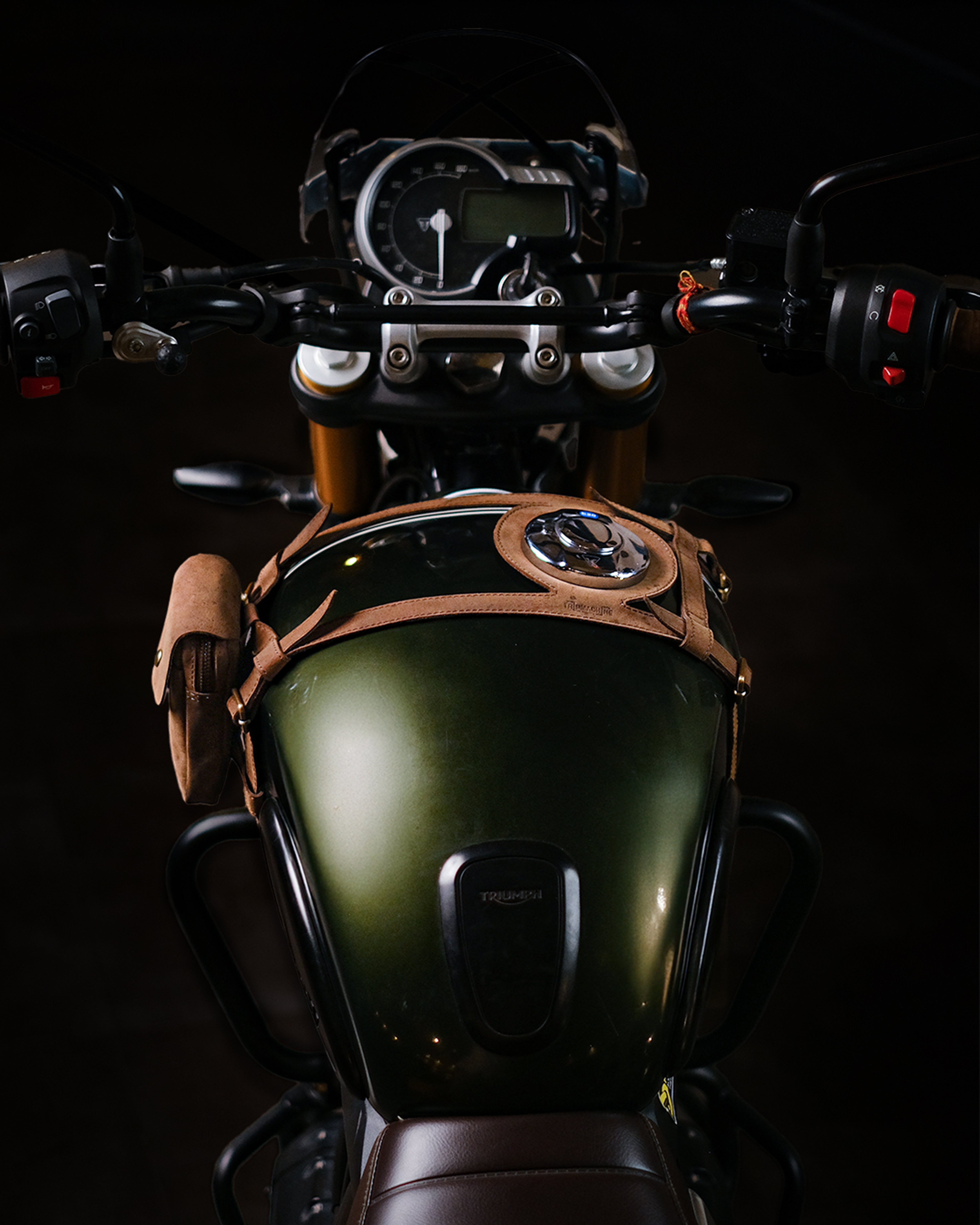 Close-up of a motorcycle's tank strap with pouch with a dark background