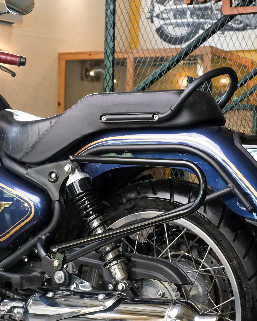 Close-up of a bullet 650 motorcycle with saddle stay inside a building.