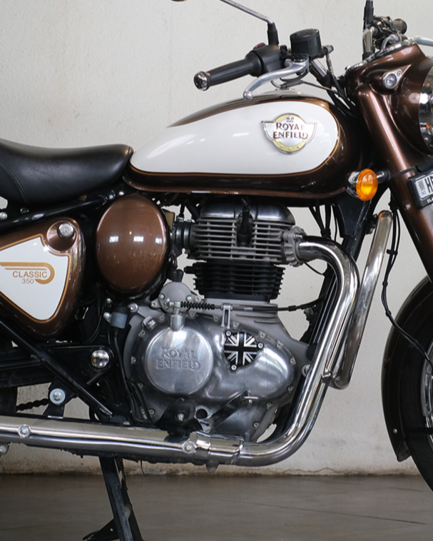 Motorcycle indoors with a plant and wall clock in the background