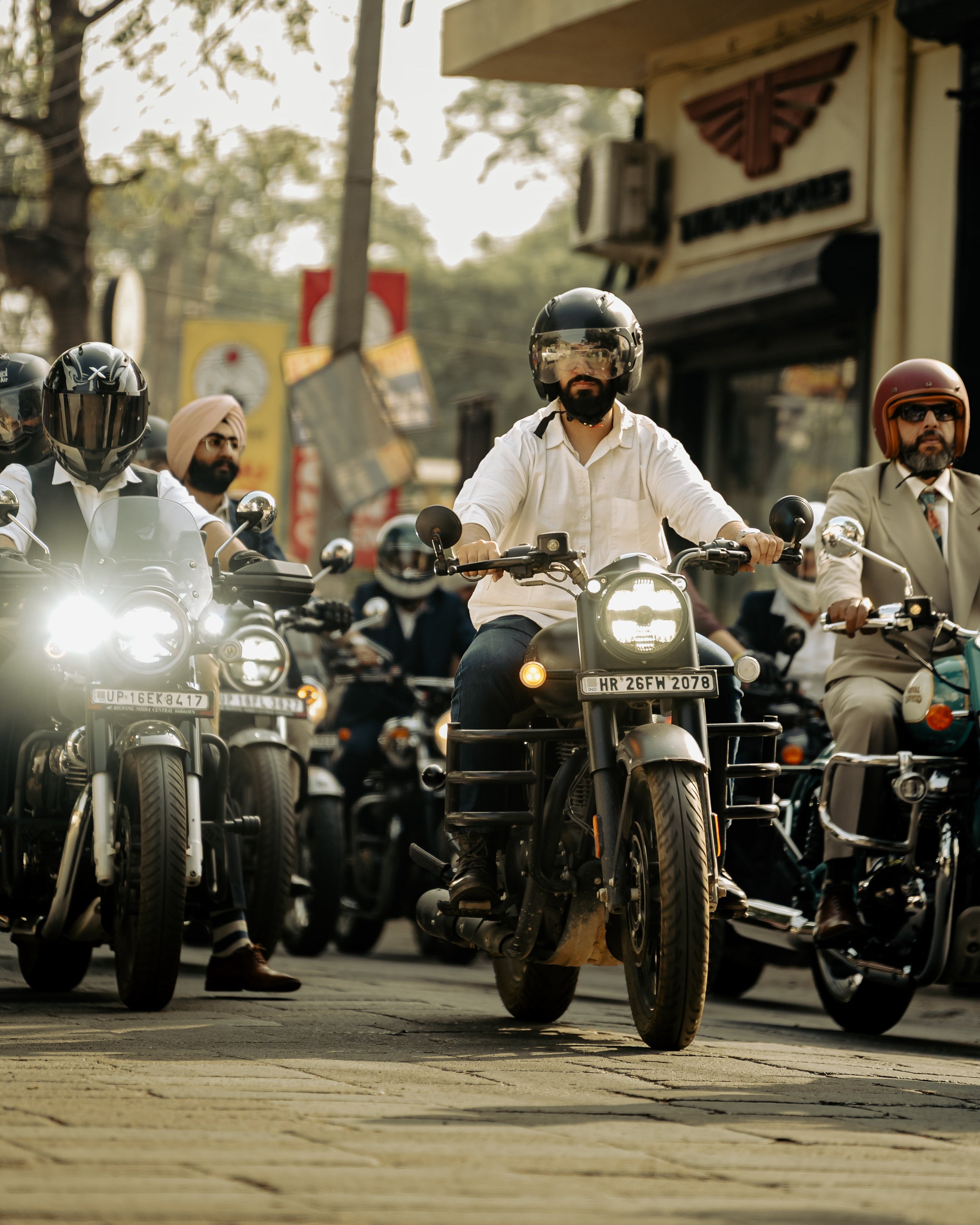 Group of motorcyclists riding on a street with a building in the background