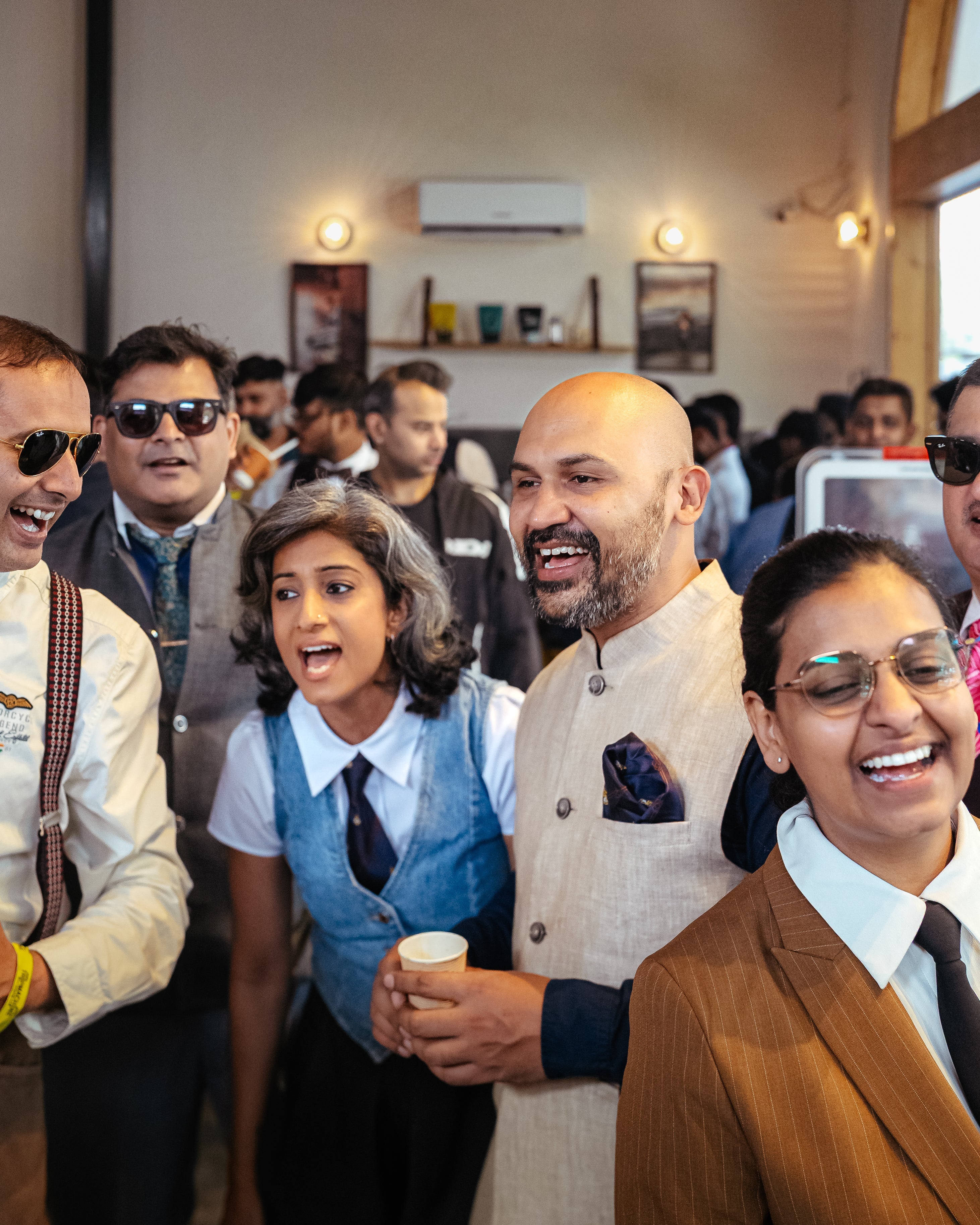 Group of people in formal attire laughing together indoors.
