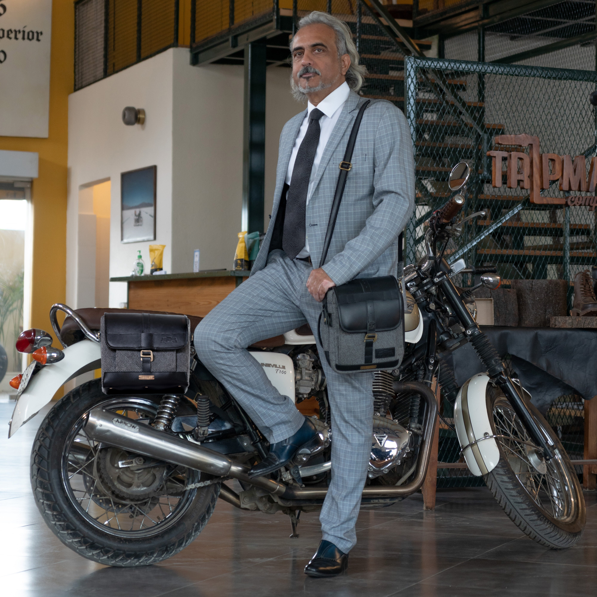 Man in a suit sitting on a motorcycle in a showroom