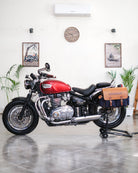 Red motorcycle with leather bags in a showroom setting