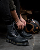 Man tying shoe lace of black color handmade genuine leather derby boots with ankle, toe and heel protector for bikers 