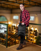 A man holding a handmade genuine leather black color eastwood backpack as a handbag