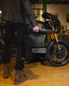 A man holding a handmade genuine leather black color eastwood backpack  as a handbag