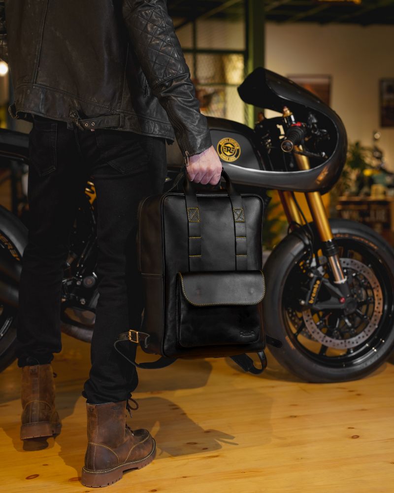 A man holding a handmade genuine leather black color eastwood backpack  as a handbag