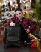 A man seated on a sofa and holding a handmade genuine leather black color eastwood backpack on a table