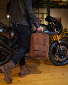 A man holding a handmade genuine leather brown color eastwood backpack used as handbag