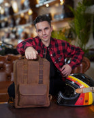 A man seated on sofa holding a handmade genuine leather brown color eastwood backpack as handbag on table