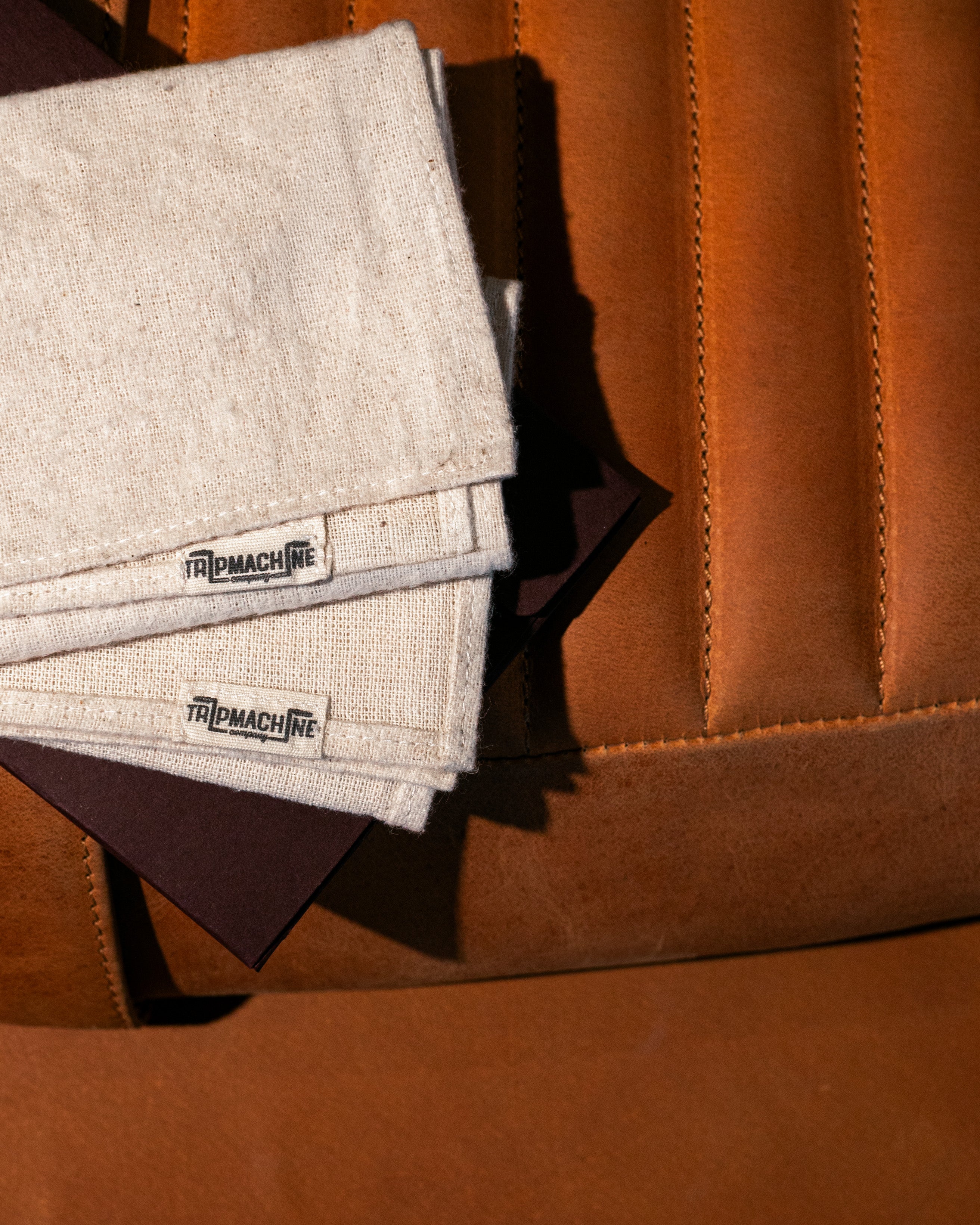 Textured fabric with 'TripMachine' label on a brown leather surface