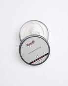 Open container of leather conditioner with visible brand name on a white background