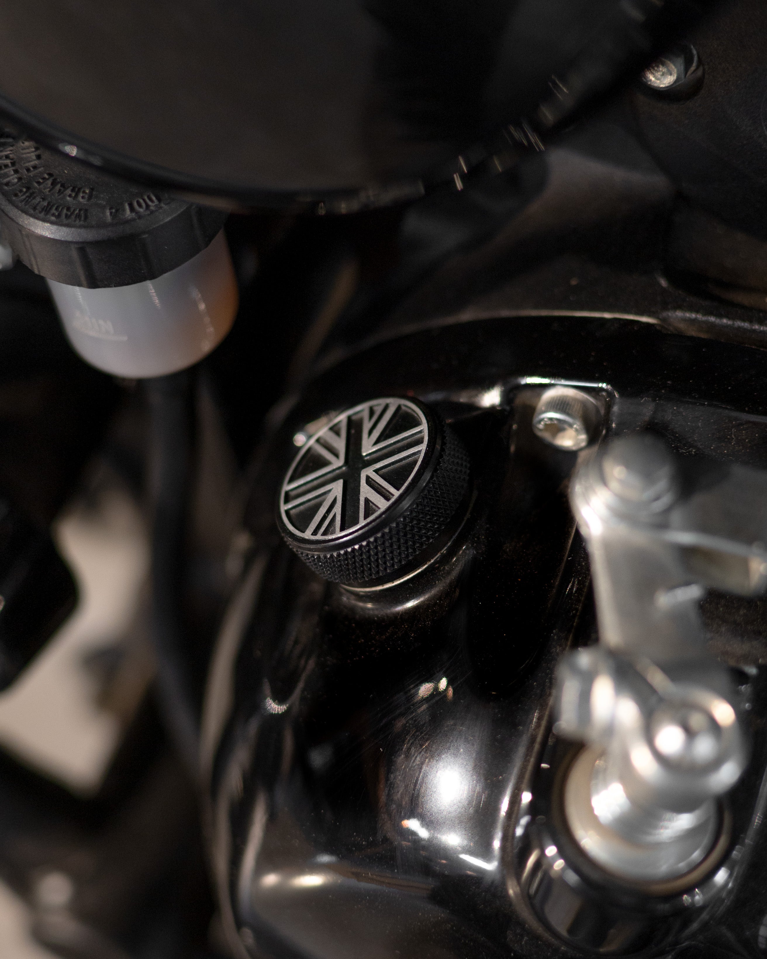 Close-up of a motorcycle handlebar with a Union Jack design on the throttle grip.