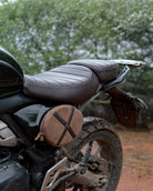 Close-up of a motorcycle seat with a brown leather cover outdoors.