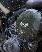 Close-up of a motorcycle engine with 'Trip Machine' branding in the snow.