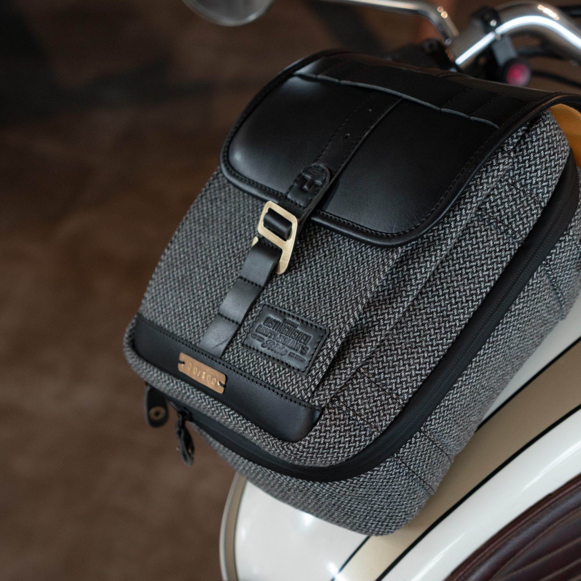 Gray motorcycle saddlebag with black flap attached to a motorcycle.