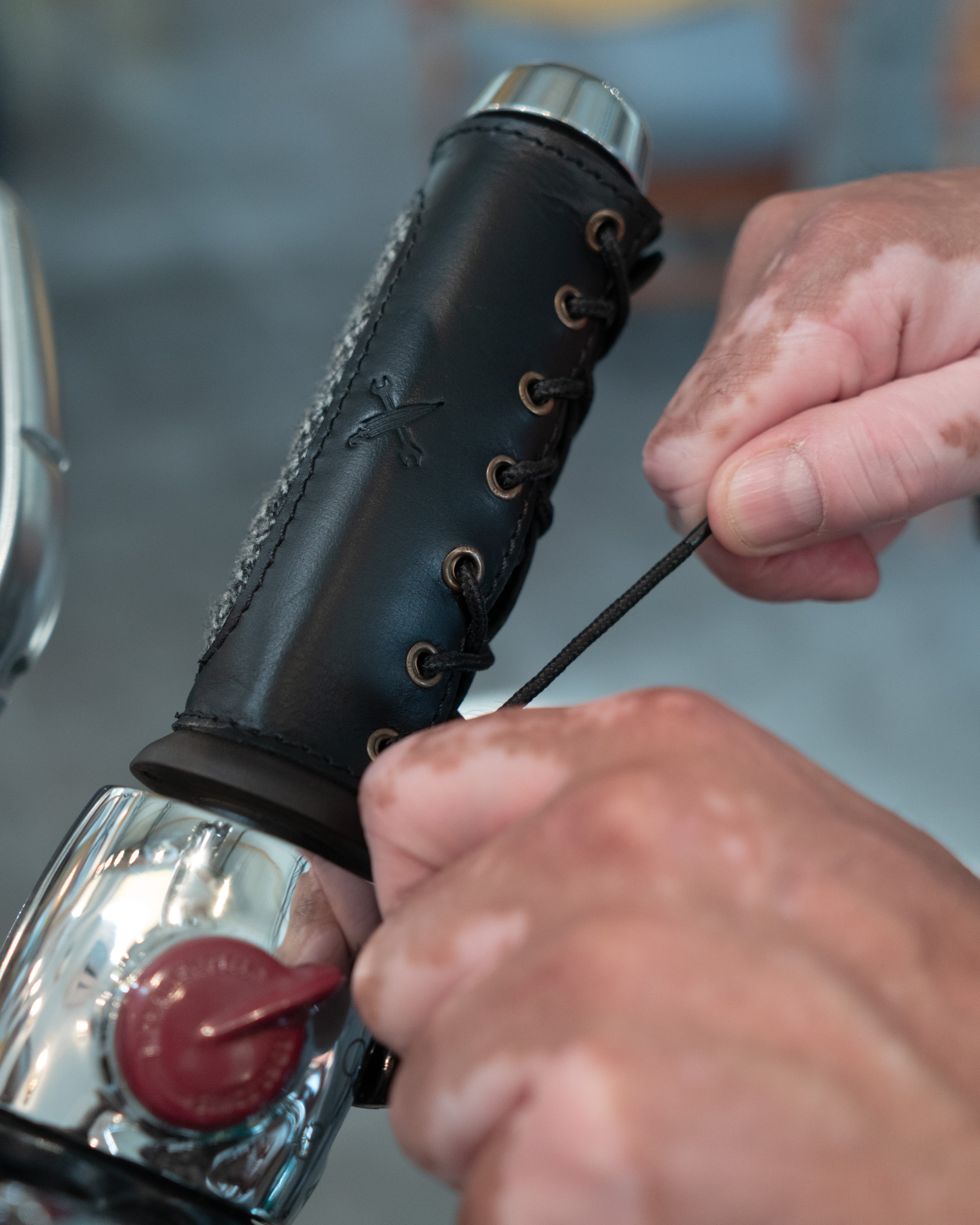 Person adjusting a motorcycle handlebar grip with a close-up view.